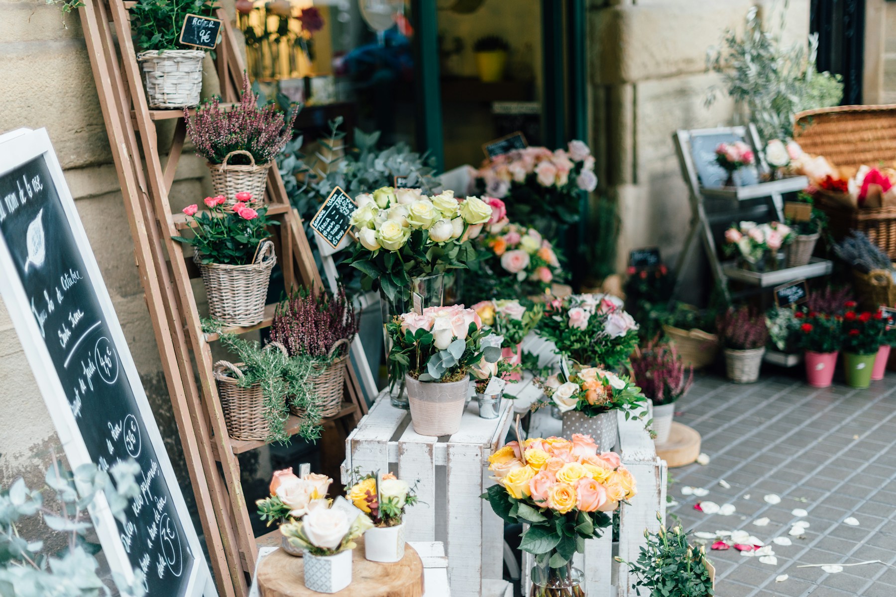 A flower market filled with blush roses, greenery, and potted blooms